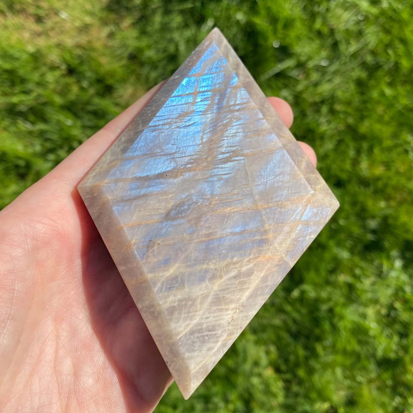 Piedra luna en forma diamante con destellos azules y morados para mejorar el aura femenino